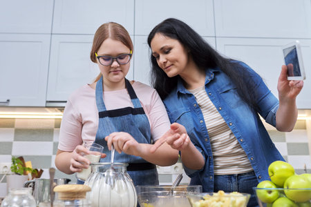 Mom and teenage daughter preparing apple pie together