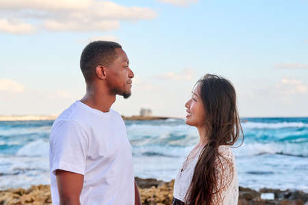 Young beautiful couple looking in the eyes in profile, on the seascapeの写真素材
