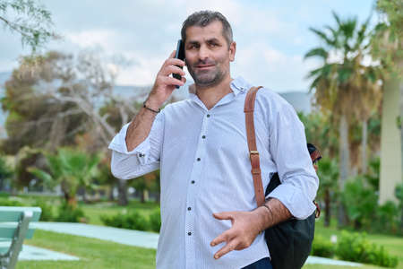 Mature man talking on the phone outdoors.の写真素材