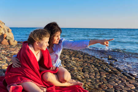 Happy mother and daughter child together on the sea beachの写真素材