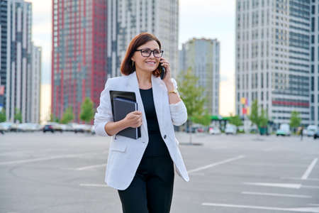 Portrait of successful mature businesswoman with smartphone outdoorの写真素材
