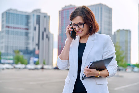 Portrait of successful mature businesswoman with smartphone outdoor