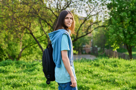 Outdoor portrait of handsome student guy with backpack looking at camera