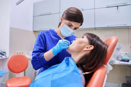 Woman patient treating teeth in clinic, treatment processの写真素材
