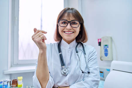 Headshot of female doctor talking to webcam, make online video callの写真素材