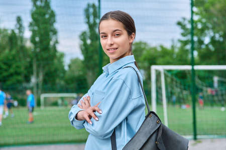 Portrait of teenage female student looking at camera, school stadium backgroundの写真素材