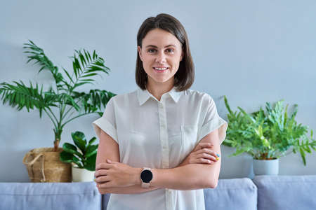 Portrait of confident young woman looking at camera at homeの写真素材