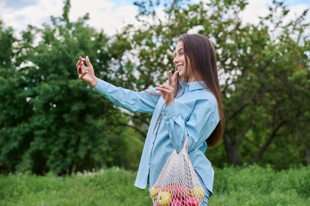 Pretty teenage girl in the park using smartphone