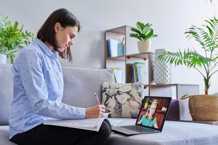 Young female teacher making video conference for child girl sitting in home