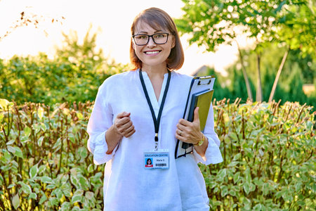 Outdoor portrait of female teacher with clipboard