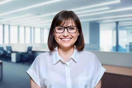 Portrait of mature business woman looking at camera in office interiorの写真素材