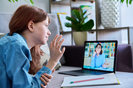 Online lesson, child girl looking at laptop screen, talking with teacher