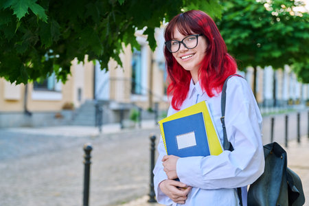 Portrait of smiling female student 18, 19 years old on city streetの写真素材