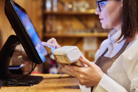 Female restaurant worker using computer terminal while serving customers