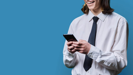 Young male in business clothes looking at smartphone screen