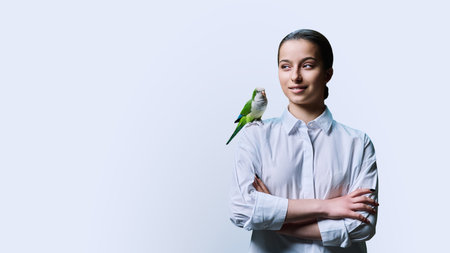 Young teenage female with green pet parrot, on white background