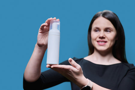 Close-up of white clean tube with cosmetic product in hands of womanの写真素材