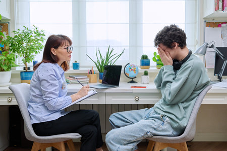 Confident serious female psychologist talking to young guyの写真素材