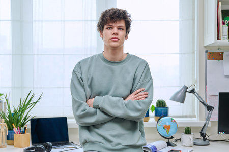 Portrait of handsome guy 19 years old looking at camera in home interiorの写真素材