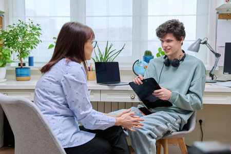 Woman social worker, mentor interviewing, talking to young male in officeの写真素材