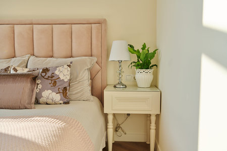 Classic bedroom interior in light ivory colors, in warm sunlight