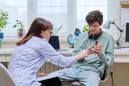 Young guy age 18-20 at therapy meeting with female psychologist, therapistの写真素材