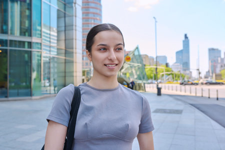 Young smiling teenage girl on street of modern city