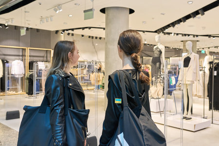 Warsaw, Poland, 12.05.2023. Two young females looking at showcase with clothes in mallのeditorial素材