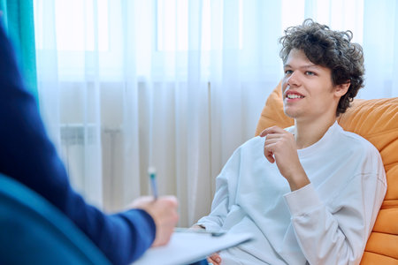 Young male college student in therapy session with psychologistの写真素材