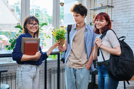 College students and female mentor teacher with bouquet of flowersの写真素材