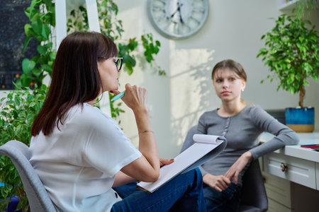 Sad teenage girl at therapy meeting with psychologistの写真素材