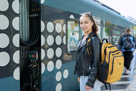 Young female waiting for an electric train at city railway stationの写真素材