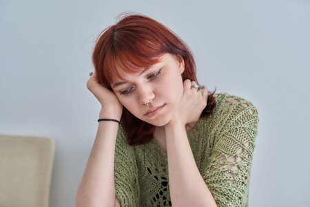 Sad upset teenage female, red-haired girl 19, 20 years old face close-up