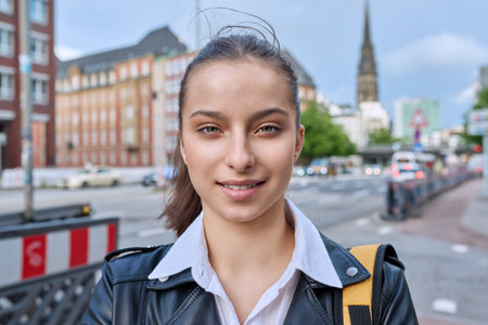 Portrait of teenage high school student girl with backpack on city streetの写真素材