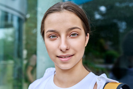 Outdoor portrait smiling high school student girl with backpackの写真素材