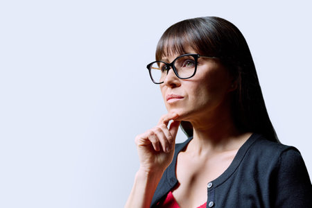 Close-up portrait of mature confident serious woman on white backgroundの写真素材