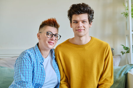 Portrait of happy middle-aged mother and son 19-20 years old hugging together
