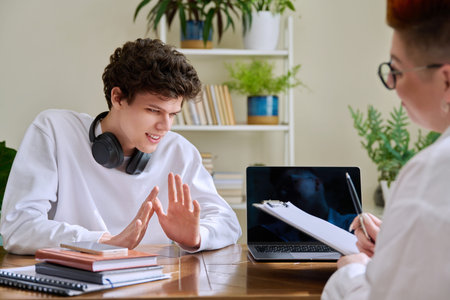 Young male college student at meeting with professional mental therapist
