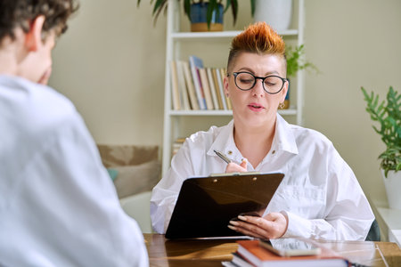 Female psychologist mental therapist working with young guy in officeの写真素材