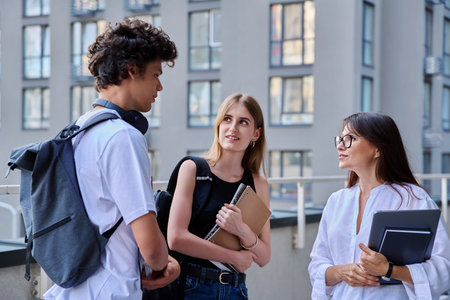 Group of college students talking with female teacher coach mentor, outdoorの写真素材