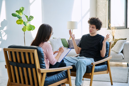 Young man in mental therapy session in office of social psychologist,counselorの写真素材