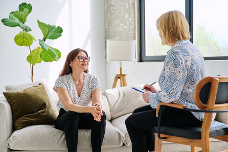 Mental therapy session, middle aged woman patient talking to professional psychologistの写真素材