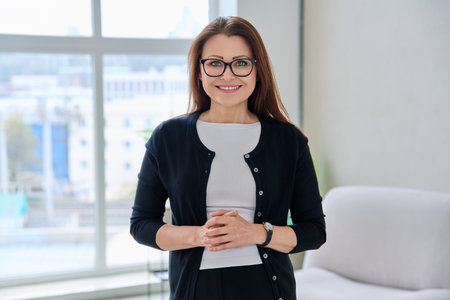 Portrait confident middle aged businesswoman posingの写真素材