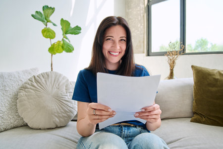 Webcam view young smiling woman with business papers having videoの写真素材