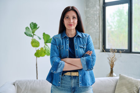 Portrait of beautiful young confident woman in home interiorの写真素材