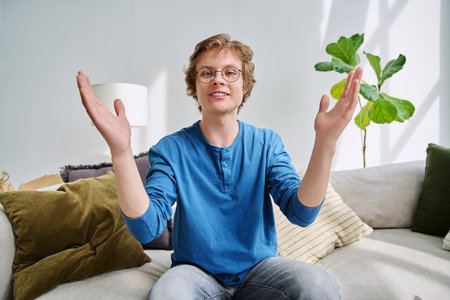 Webcam portrait male student teenager with glasses, sitting at homeの写真素材