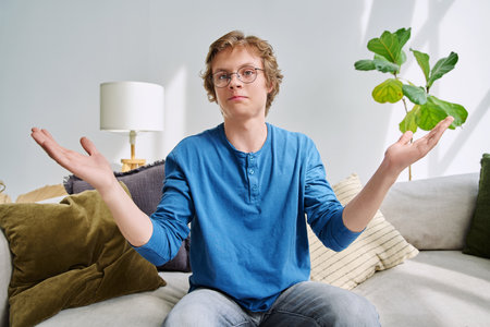 Webcam portrait male student teenager with glasses, sitting at homeの写真素材