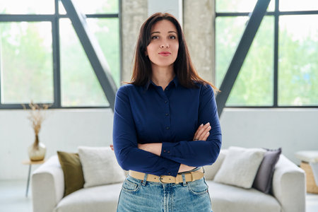 Portrait of beautiful young confident woman in office with couchの写真素材