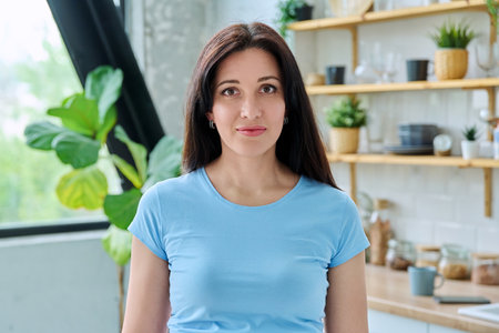 Headshot portrait young smiling woman at home in kitchenの写真素材