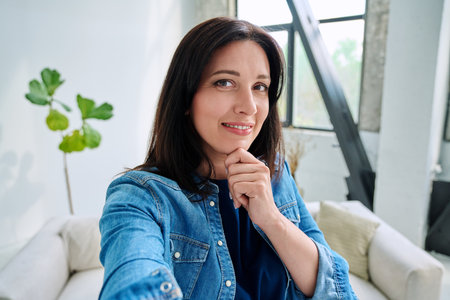Selfie portrait happy beautiful woman in home interiorの写真素材
